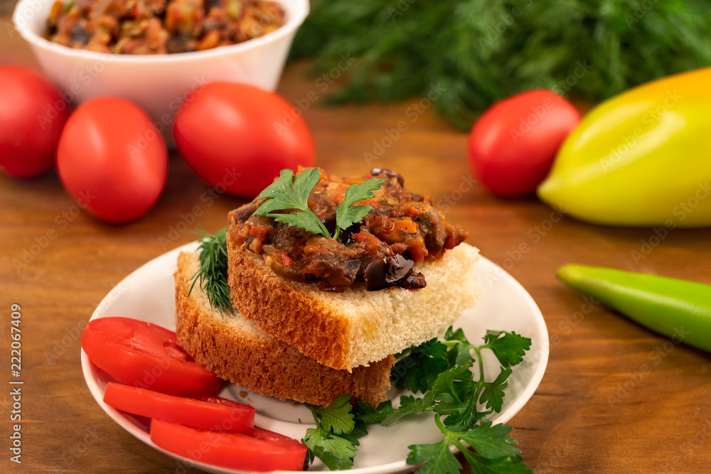 Appetizer of bread with stewed sliced vegetables on the background of whole ripe tomatoes, peppers and dill leaves. Appetizer of bread with stewed sliced vegetables on the background of whole ripe tomatoes, peppers and dill leaves.