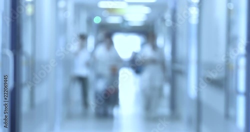 Doctors, nurses, patients and other employees walk around the hospital ward. Blur, Unfocus.