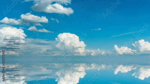 futuristic background consisting of Time lapse clip of white fluffy clouds over blue sky and their reflection, video loop photo