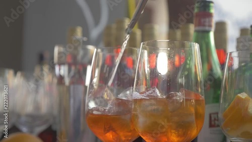 Barkeeper mixing a drink called Aperol spritz. (Adding Prosecco) //close up, hand held, low angle, slow motion (made with 50fps)// photo