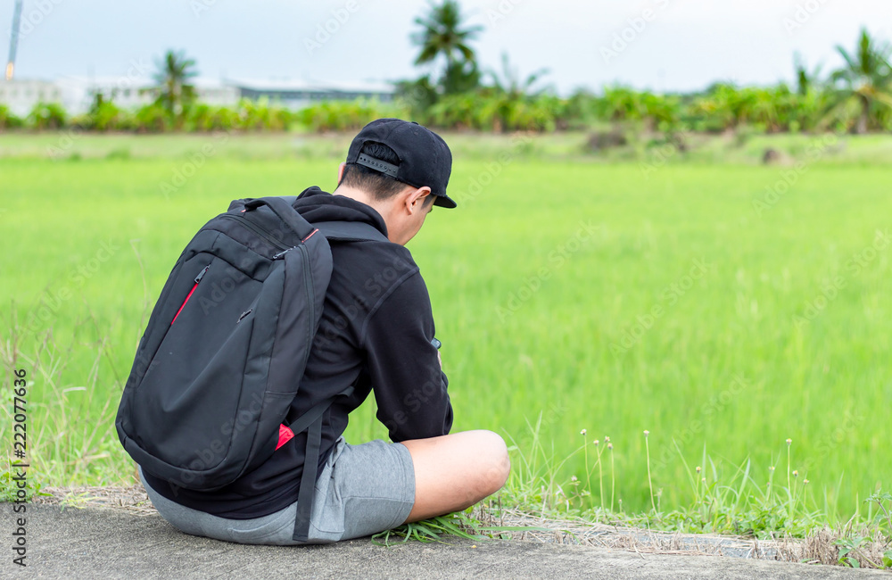 The man sitting on the road beside the rice fields. The man sitting on the road beside the rice fields.