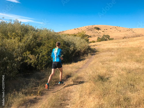 Man on a trail run in foothills