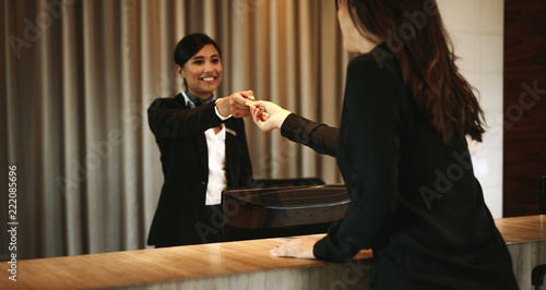 Φωτογραφία Female guest taking room key card at check-in desk