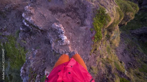 Epic action footage from a dangerous hike on a mountain top in Thorsmork Iceland. Powerful Icelandic mountain scenery. Steep cliffs on both sides of the hiker. Beautiful summer sunset colours. photo