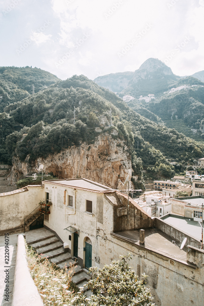 Obraz premium The Amalfi coast and the mountain slopes with plantations of lemons. Panoramic view of the city and nature of Italy. Evening landscapes and winding roads