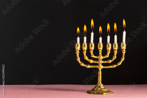 Bronze Hanukkah menorah with burning candles