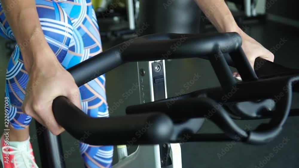 Exercise bike - A woman exercising on a stationary bike in a gym Exercise bike - A woman exercising on a stationary bike in a gym