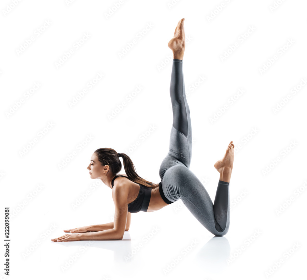 Beautiful young girl doing yoga or pilates exercise isolated on white background. Concept of healthy life and natural balance between body and mental development. Full length Stock Foto Adobe Stock