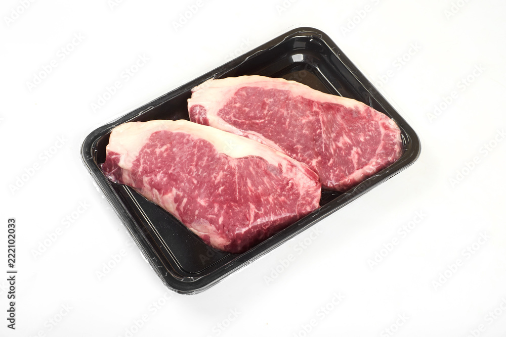 Raw steak in an airtight vacuum package on a white background. Raw steak in an airtight vacuum package on a white background.