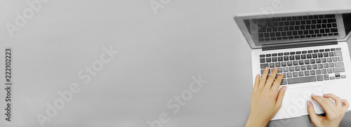 Website banner of top view laptop and female hands with copyspace in grey color background. Concept of blog header and advertisement of business company.