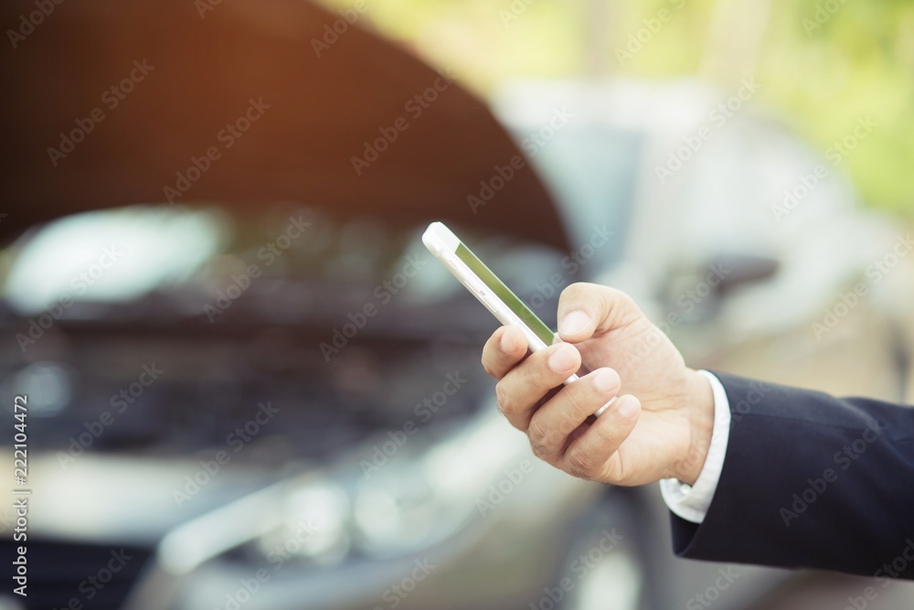 close up businessman hand using a mobile smart phone call a car mechanic ask for help assistance because car broken roadside.  - obrazy, fototapety, plakaty 