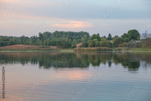 Sunset with orange sunlight, lake and reflection. Meadow and trees. Nature photo. Travel photo 2018.