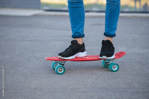 Some of the legs are on a skateboard close up. young sport. leisure. penny board