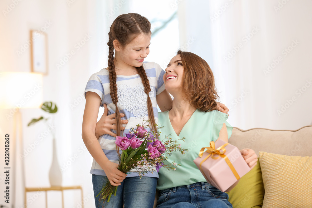 Cute little girl greeting mother at home