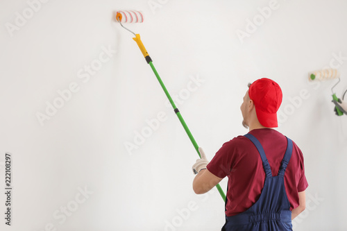 Male painter in uniform wor...
