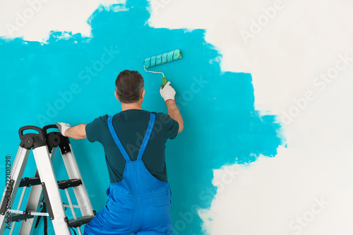 Male painter in uniform wor...