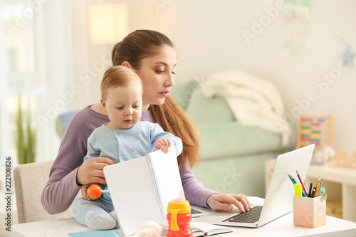 Young mother with baby work...