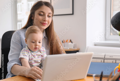 Young woman with baby worki...