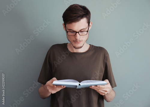 Young man reading book on c...