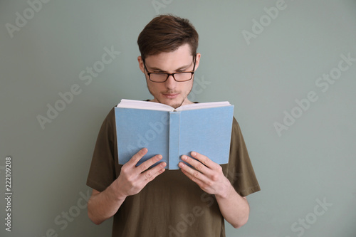 Young man reading book on c...