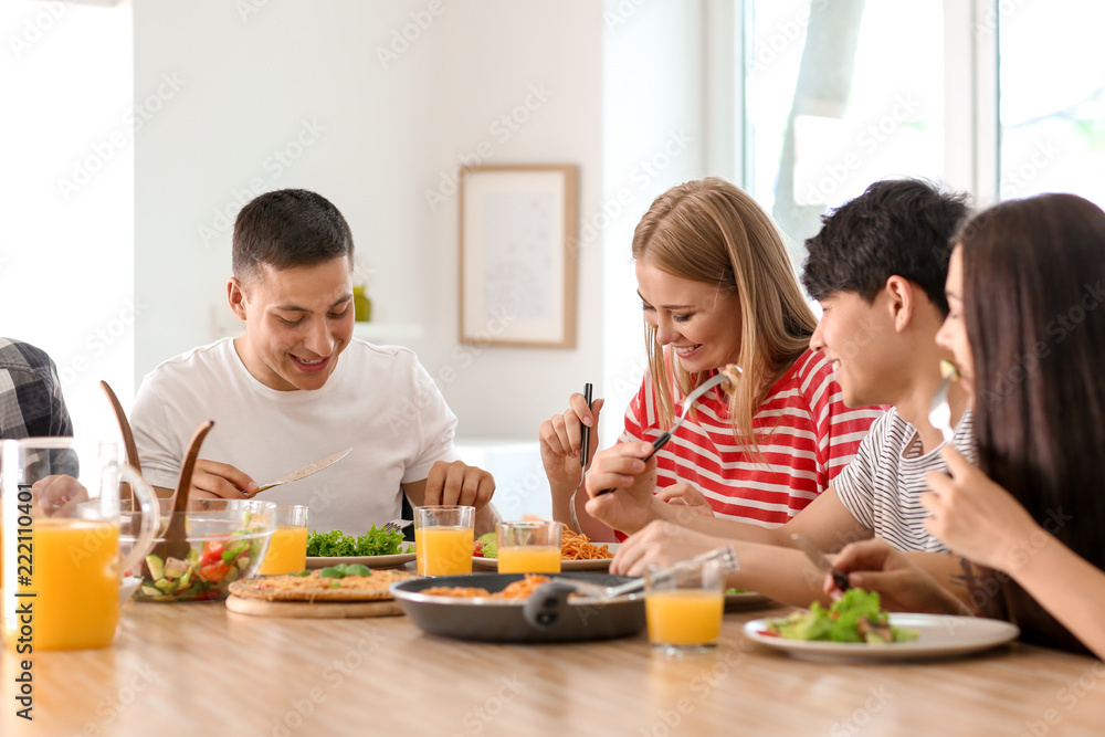 Friends eating at table in kitchen