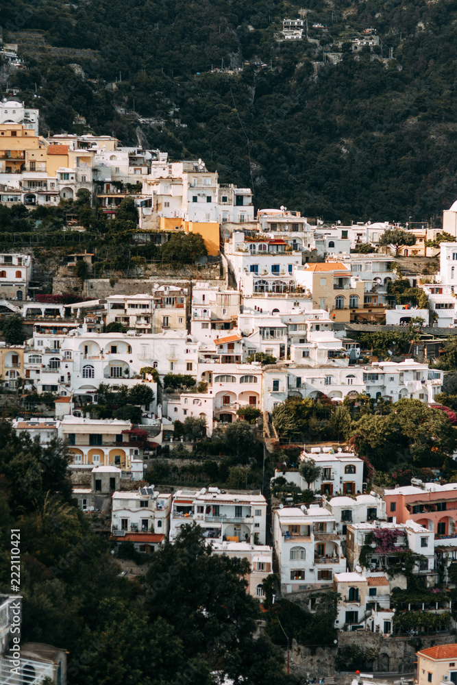 The coast of Positano, Amalfi in Italy. Panorama of the evening city and the streets with shops and cafes. Houses by the sea and the beach. Ancient architecture and temples