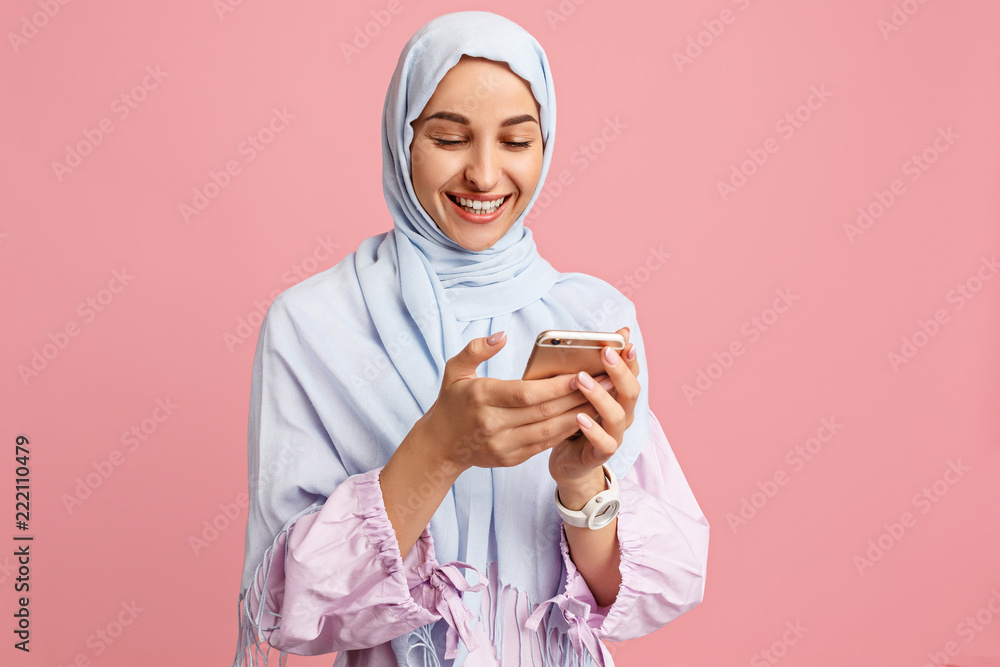 Foto Stock Happy arab woman in hijab with mobile phone. Portrait of ...