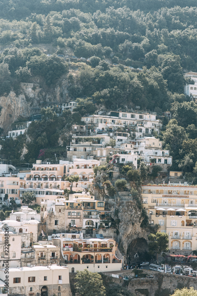 The coast of Positano, Amalfi in Italy. Panorama of the evening city and the streets with shops and cafes. Houses by the sea and the beach. Ancient architecture and temples