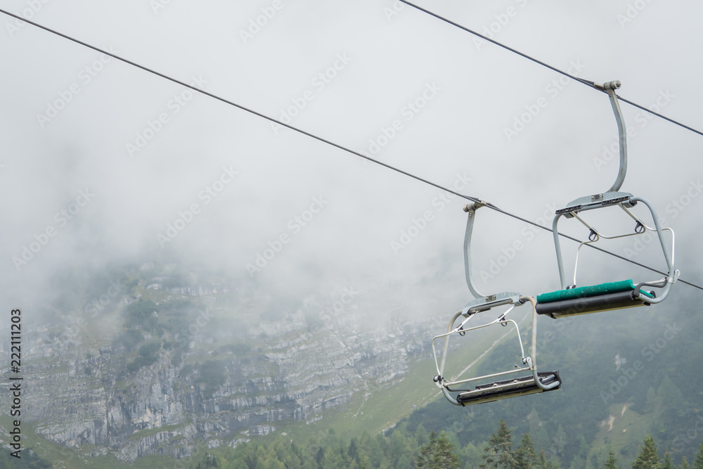 A chairlift with mountains and fog in the background