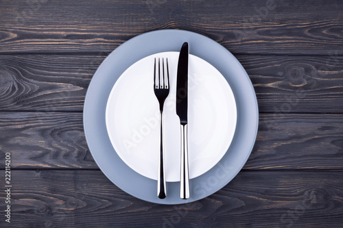 Serving wooden table with empty plate  fork and knife. Top view.