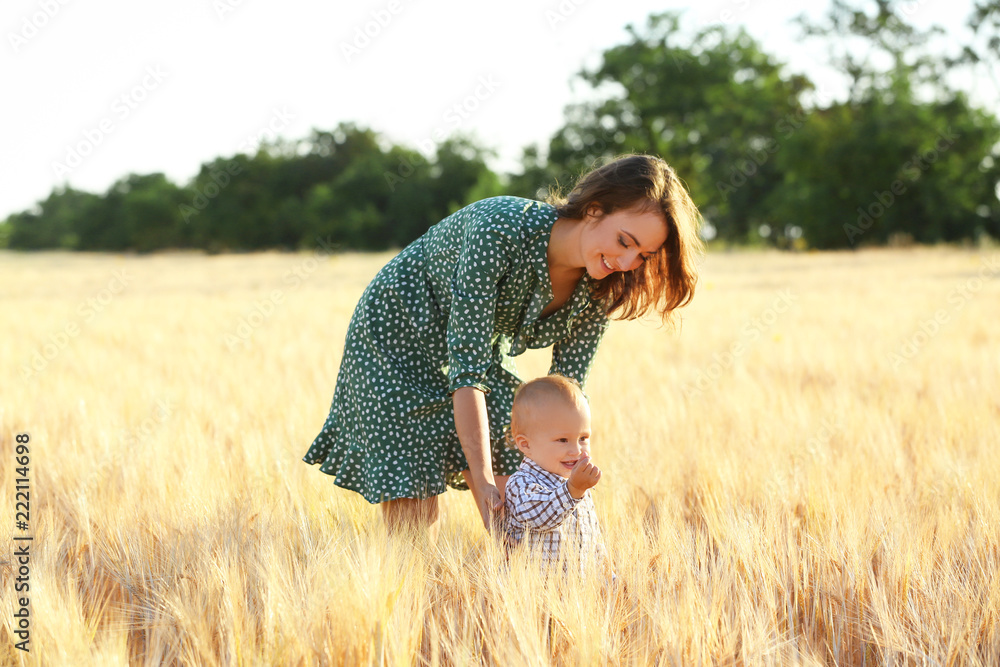Beautiful woman with her little son in wheat field on summer day Beautiful woman with her little son in wheat field on summer day