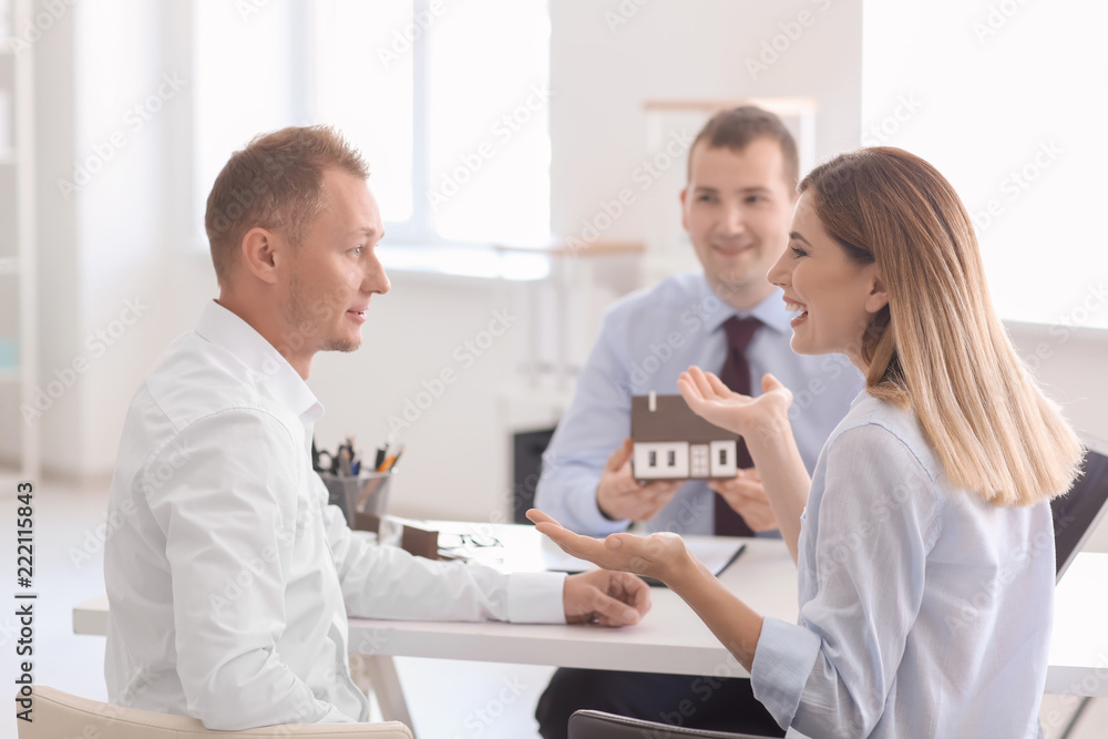 Obraz premium Beautiful couple with real estate agent in office