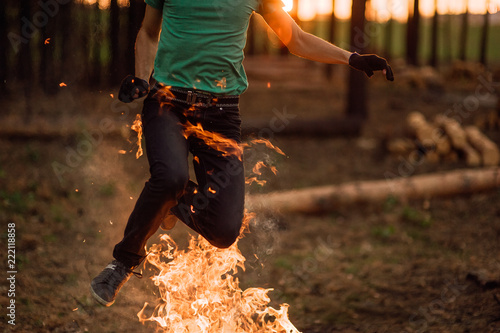 man is jumping over a fire