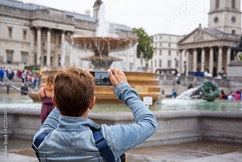 Sticker Tourist takes a photo with her smartphone in Trafalgar Square