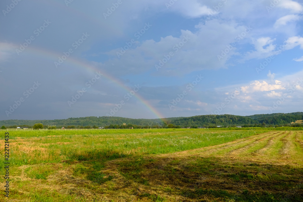 rainbow in the field against the beautiful sky rainbow in the field against the beautiful sky