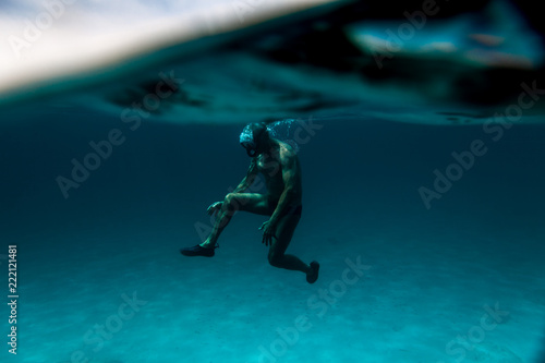 interesting under-water view of a Senior man floating on the ocean