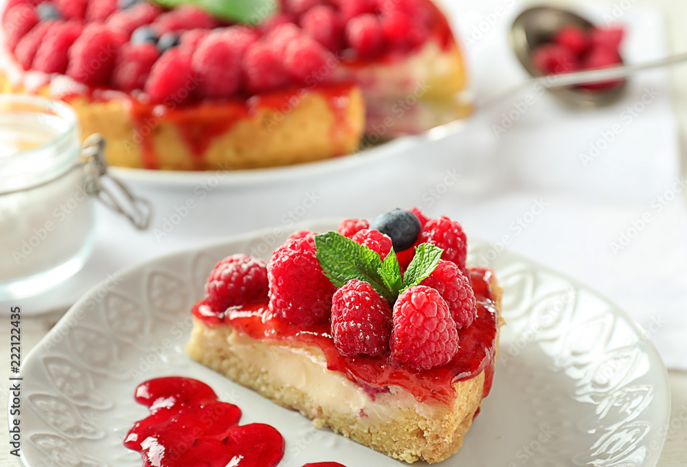 Plate with piece of delicious raspberry cheesecake on table Plate with piece of delicious raspberry cheesecake on table
