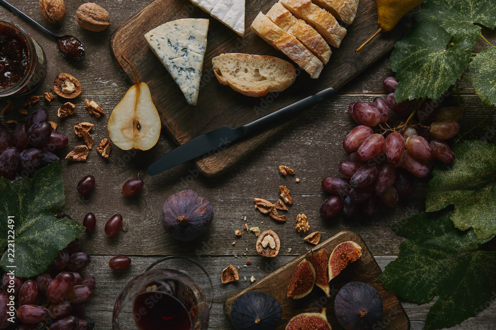 top view of glass with red wine, fresh fruits and delicious snacks on wooden table top view of glass with red wine, fresh fruits and delicious snacks on wooden table