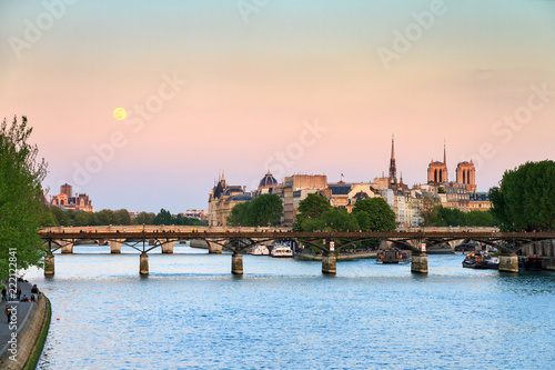Full moon rise at a pink twilight over the Seine in Paris  France  