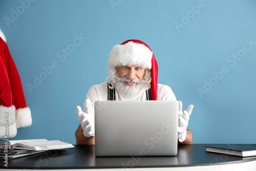 Santa Claus working on lapt...