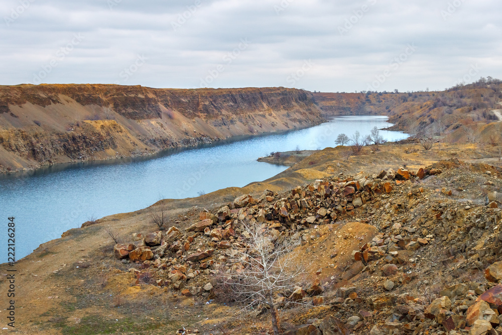 The long lake in the disused sandstone quarry. Brown moody industrial landscape
