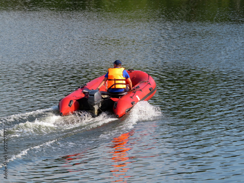 Man driving a motor boat. Lifeguard in a life jacket, rescue drowning, safety on the water, river patrol