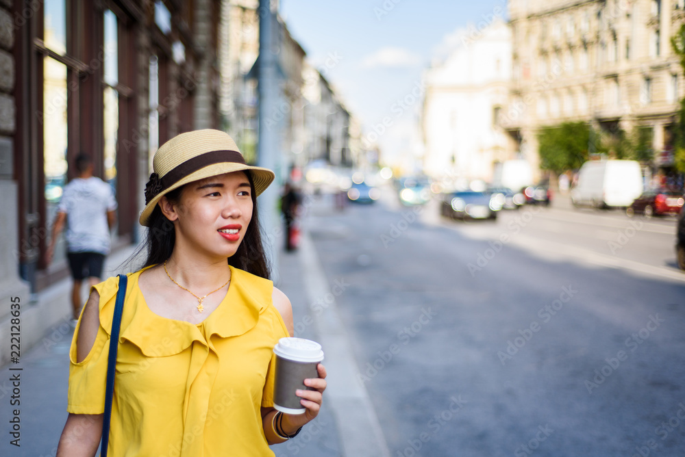 Fototapeta premium Girl walking on the street with coffee to go