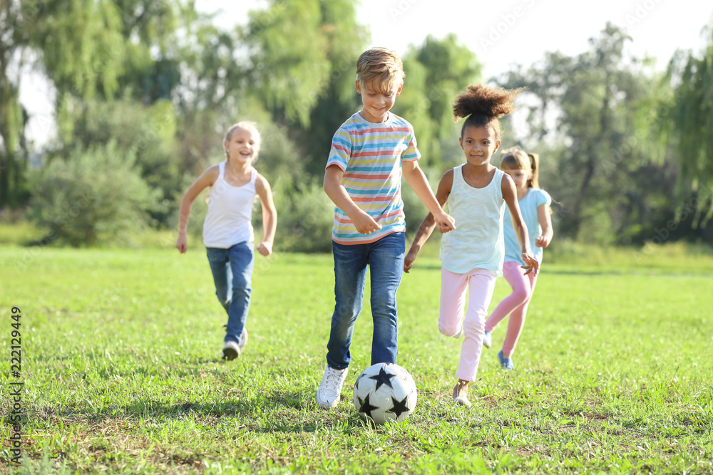 Cute little children playing football outdoors Cute little children playing football outdoors