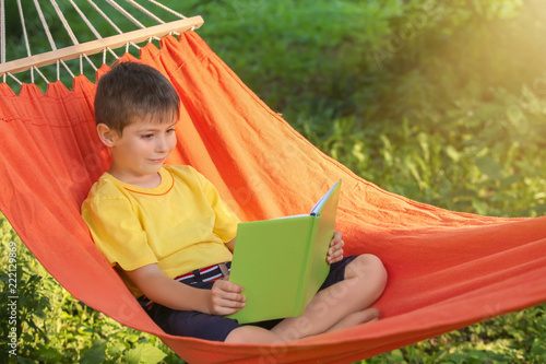 Cute little boy reading boo...