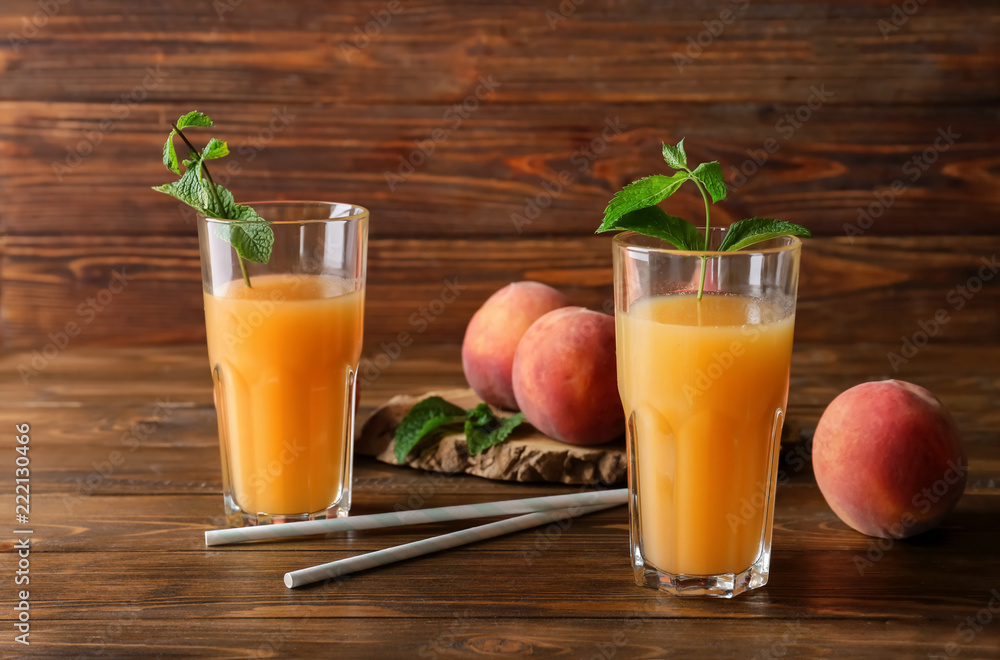 Fototapeta premium Peach juice in glasses on wooden table