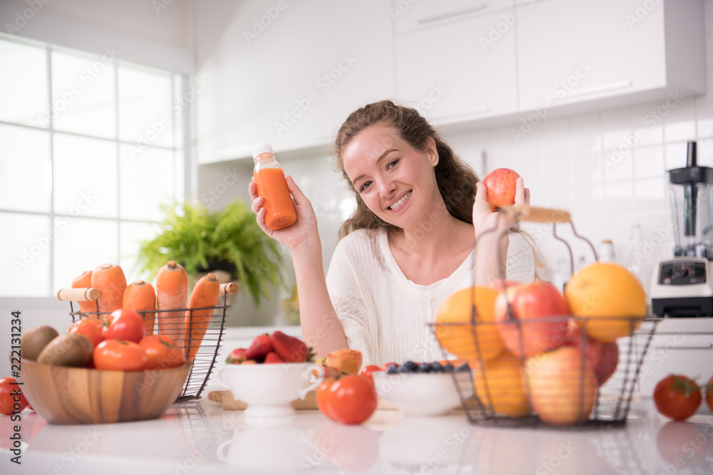 Healthy young woman in a kitchen with fruits and vegetables and juice Healthy young woman in a kitchen with fruits and vegetables and juice