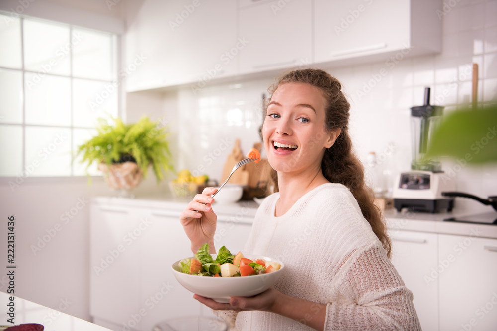Healthy young woman eating salad in the kitchen Healthy young woman eating salad in the kitchen