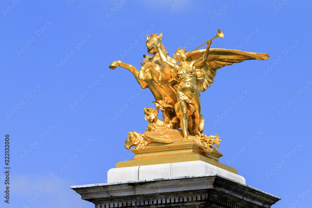 Fototapeta premium Golden statue against a blue sky on top of the pont Alexandre III at Invalides in Paris, France 