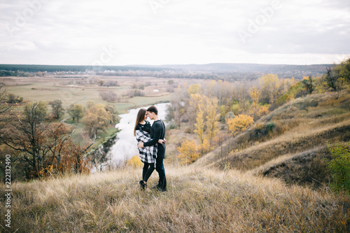 Lovers walking in the mountains. Autumn love of two happy people. Lovebirds are embracing. Beautiful place for date.